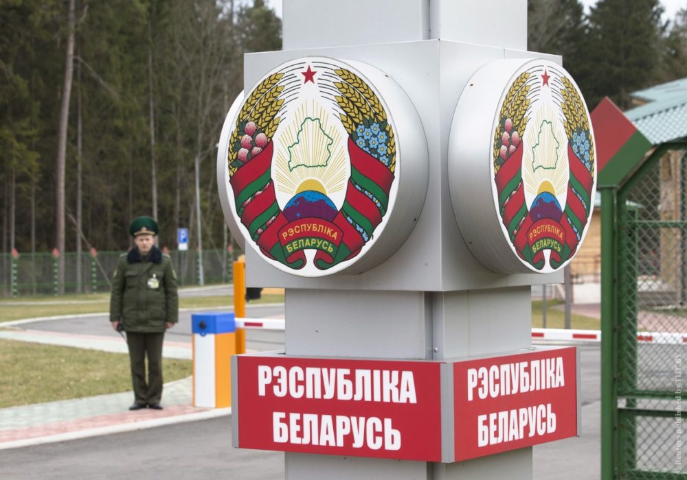 A Belarussian border guard stands near a pole with the state emblem, reading, "Republic of Belarus" at a border crossing with Poland near the village of Pererov, southwest of Minsk, March 31, 2015. Belarus plans to open this border crossing for crossing on foot and by bicycle for foreign tourists visiting the national park "Belavezhskaya Pushcha" from the Polish side, for three days without visas, according Belarussian border guards officials. REUTERS/Vasily Fedosenko - RTR4VMSS