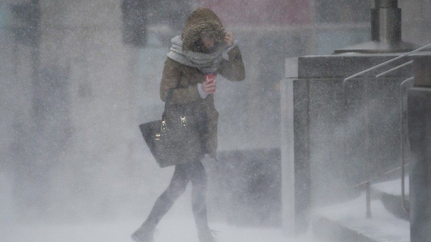 A woman keeps her head down as she walks along a street during a winter storm in Montreal, Tuesday, March 14, 2017. THE CANADIAN PRESS/Graham Hughes